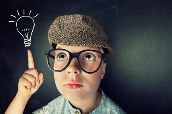 Enfant à lunettes levant le doigt devant une ampoule dessinée, atelier créatif d'anniversaire Anni-Zen